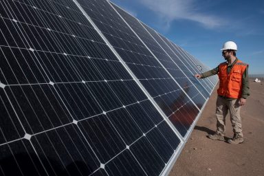 worker checks, solar panels, working properly