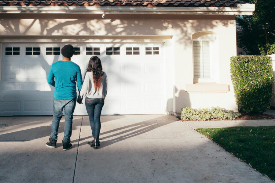 Couple standing, front of a house