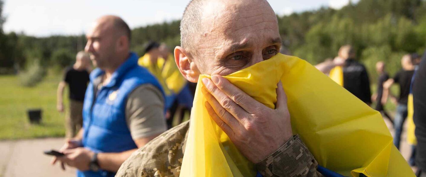 Ukrainian soldier, Ukrainian flag, emotional about loss of life, Russian attacks