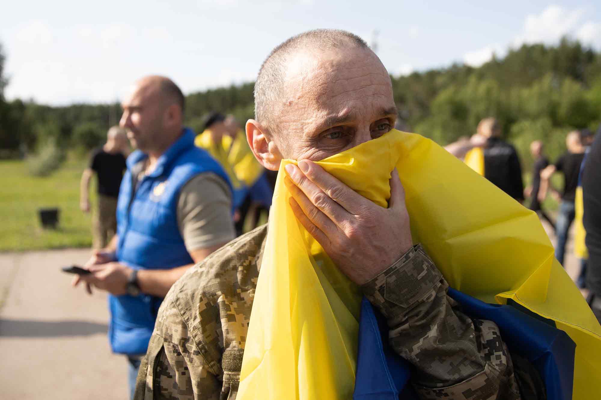 Ukrainian soldier, Ukrainian flag, emotional about loss of life, Russian attacks