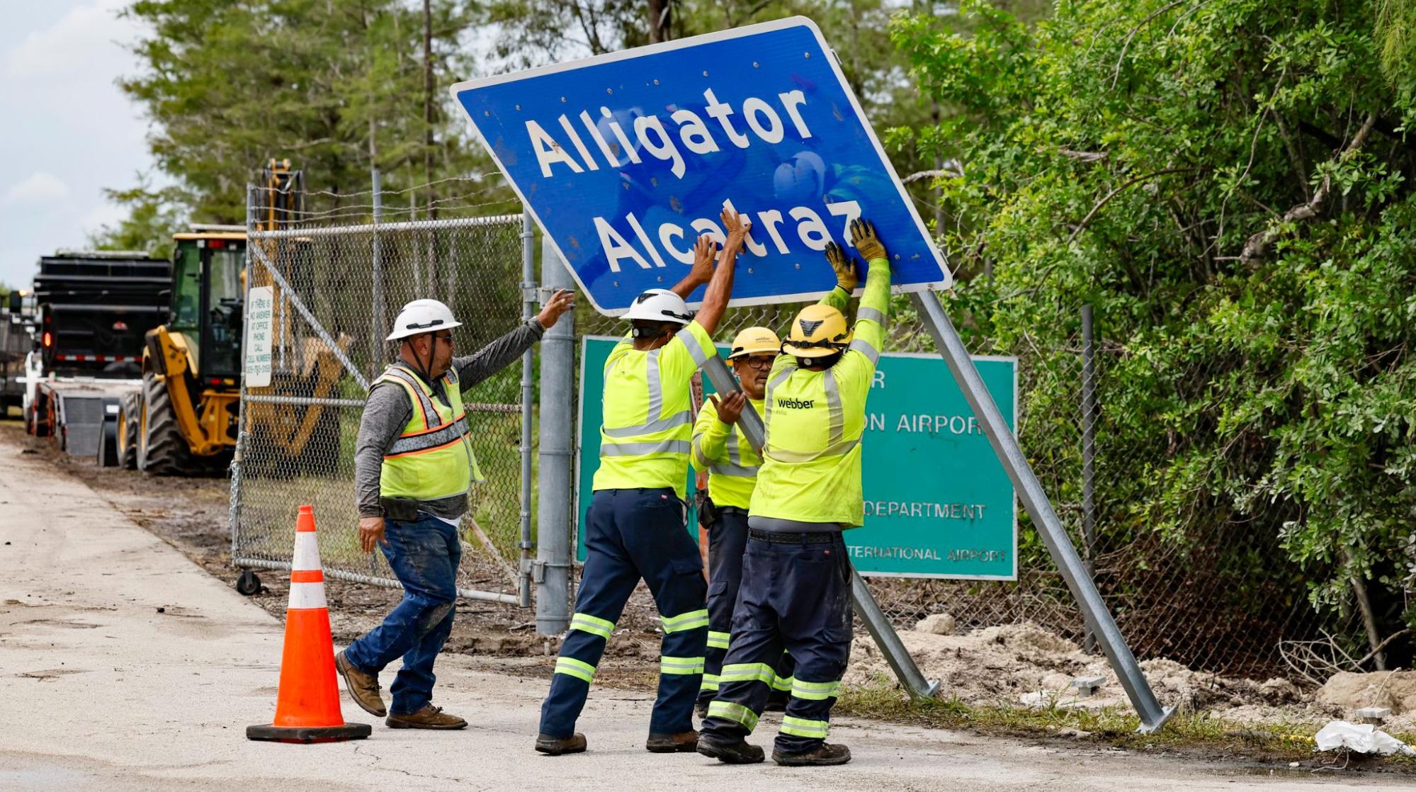 Workers, install, Alligator Alcatraz, sign