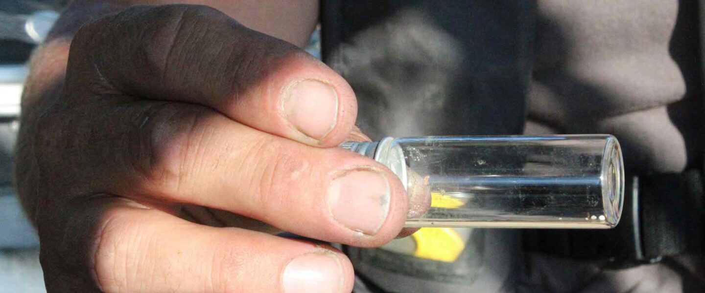 Captain Evan Clark, jar containing nurdles, water pollution
