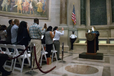 Judge Blocks Trump Administration from Discriminating Against New Citizens Citizenship candidates, take the oath of allegiance, naturalization ceremony
